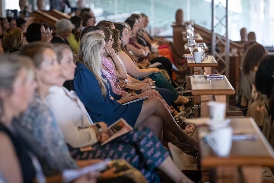 Row of women seated at conference with desks